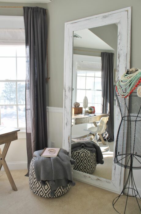 Rincón de una habitación decorado con un espejo de cuerpo completo