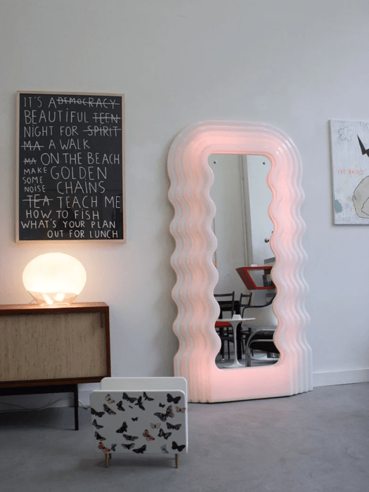 Rincón de una habitación decorado con un espejo de cuerpo completo