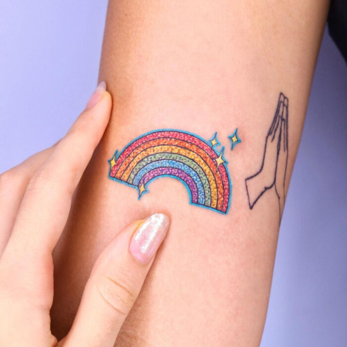 Diseños elegantes de tatuajes de arcoíris en el brazo