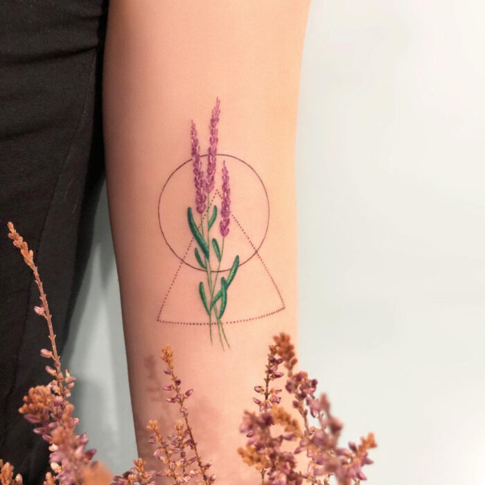 Tatuajes bonitos, pequeños y femeninos; tatuaje de espiga de lavanda con figuras geométricas, círculo y triángulo en el brazo