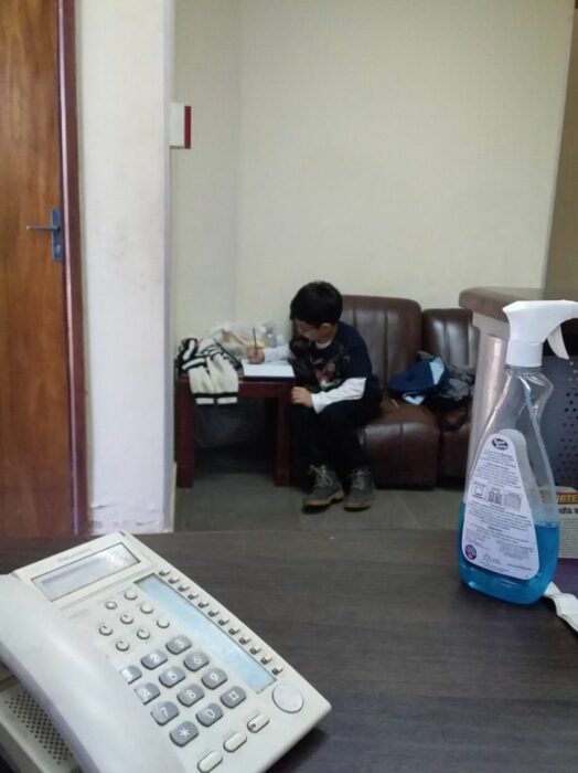 Niño sentado en un sofá haciendo tarea; Niño acompaña a su mamá al trabajo para hacer sus tareas y se vuelve viral