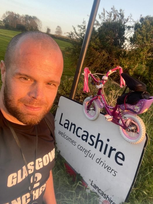 Hombre tomando una selfie con una bicicleta rosa