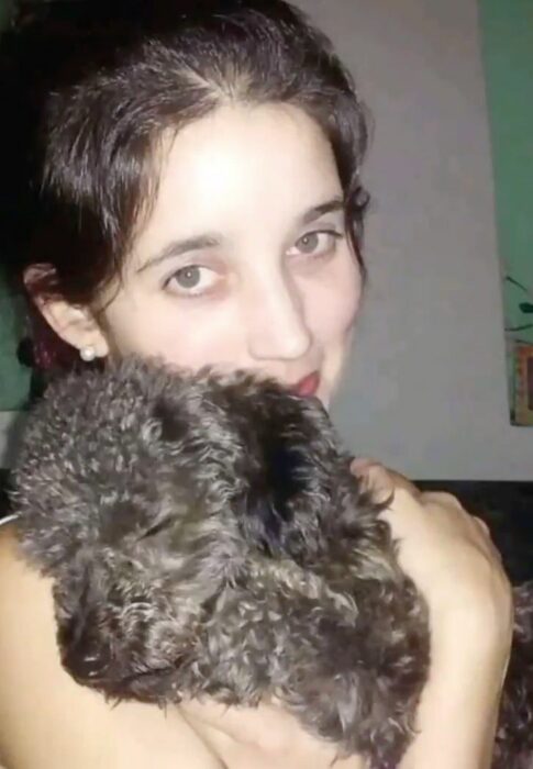 Johanna cargando a su perro Benito, un frenshpoodle negro que se ha quedado dormido