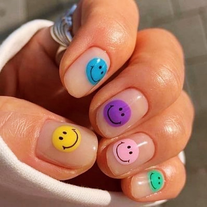 diseño de uñas con caritas felices en varios colores