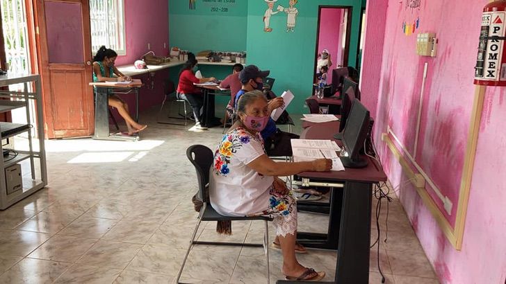 Abuelita sentada frente a un escritorio practicando computación ; ¡Nada es imposible! Abuelita de 71 años concluye sus estudios básicos