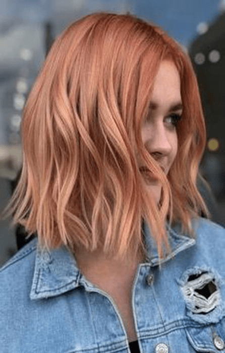 Chica mostrando su cabello teñido en peachy copper