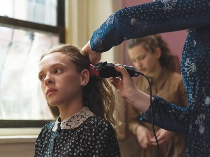 Escena de la serie Poco ortodoxa, Esty cortando su cabello a rapa para llevar peluca