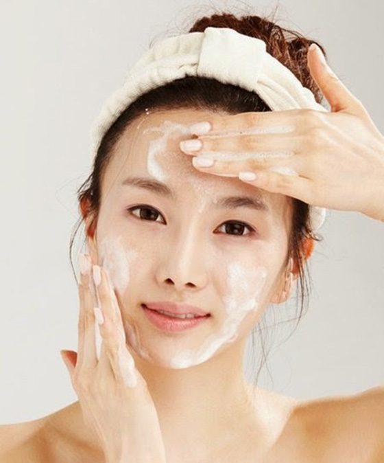 Chica limpiando su rostro frente al espejo; 'Saho', el ritual para cuidar de tu piel con un toque japonés